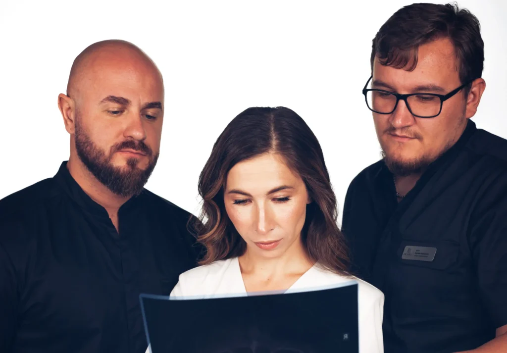 Марія Стецик, лікарі Чуп та Штурмак під час аналізу рентгенівського знімка та планування встановлення коронок у клініці PICASSO, Ужгород